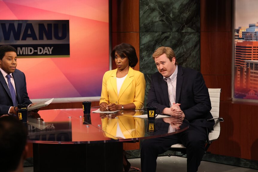 Kenan Thompson, Ego Nwodim, and Shane Gillis in suits sitting around a table.